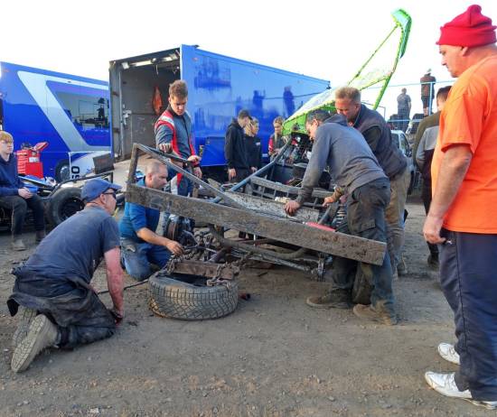 78 - A brightly attired Simon Binder (128) observes the front axle repairs after Heat 3
