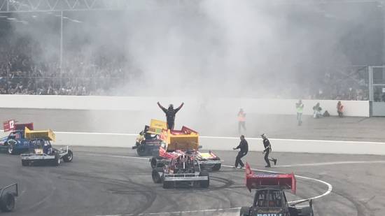 197, climbs on top of his wing to celebrate and acknowledge the crowd as his smoke fades
