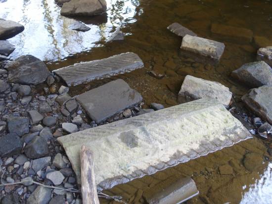 The dressed coping stones have fallen into the brook beneath
